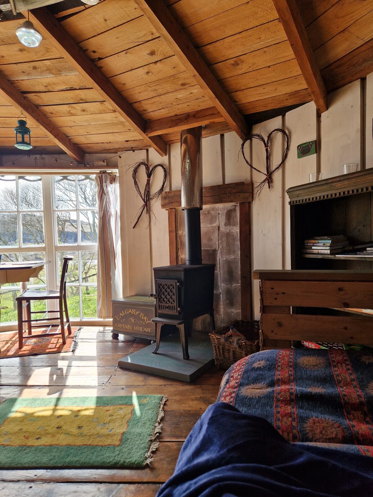 The stove corner with wrought-iron heart decorations and sunlight streaming through the windows